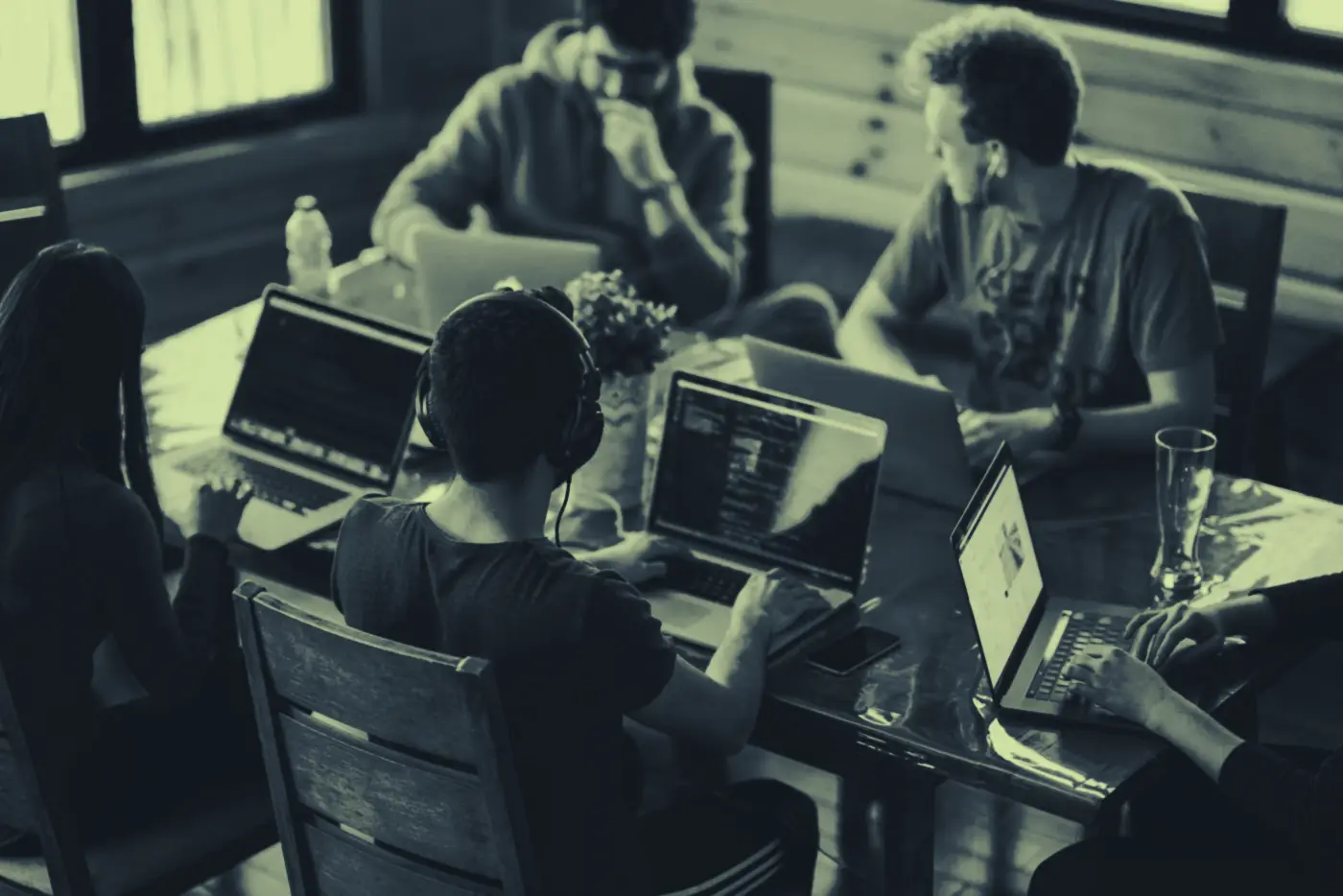 Equipo de desarrollo trabajando en conjunto alrededor de una mesa